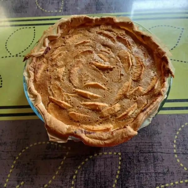 Goldbraune Elsässer Apfeltarte, Apfelscheiben in der Creme, in einer Glasform