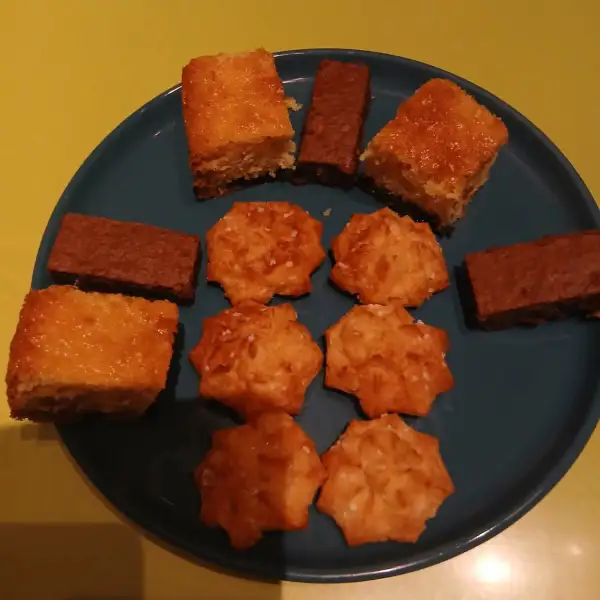 Assiette de douceurs maison : carrés moelleux dorés, bâtonnets de brownies et sablés au sucre perlé sur une assiette bleue
