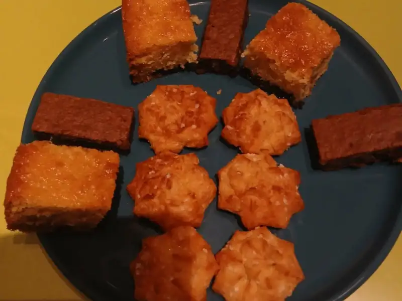 Assiette de douceurs maison : carrés moelleux dorés, bâtonnets de brownies et sablés au sucre perlé sur une assiette bleue