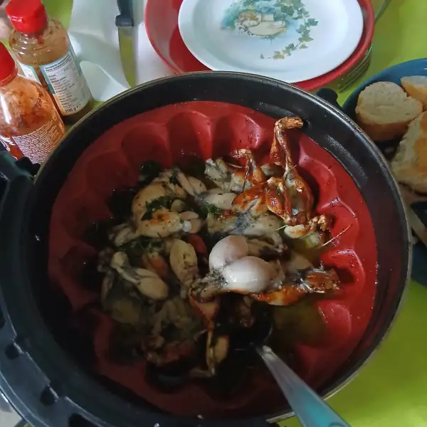 Cuisses de grenouille à l'ail et au persil dans le moule en silicone rouge de l'air fryer, servies avec du pain