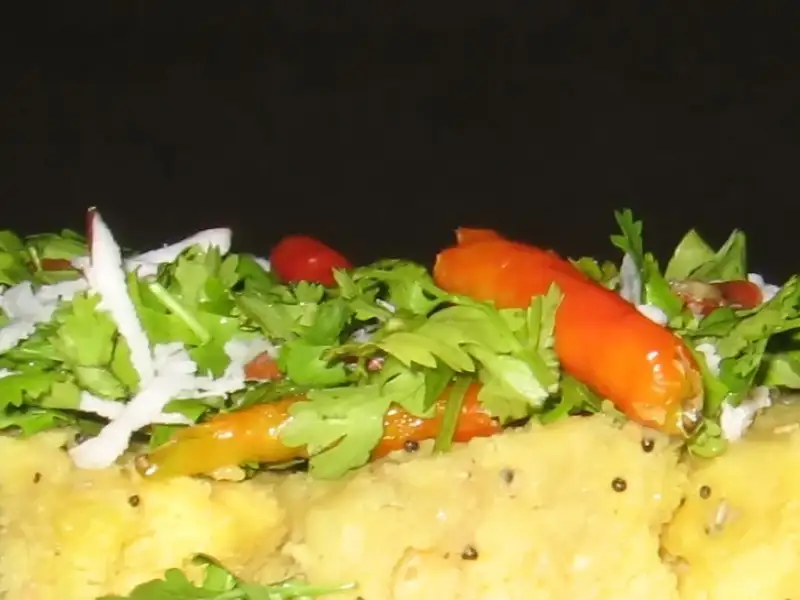 Dhokla, un dolce a base di riso e lenticchie nere, cotto a vapore.