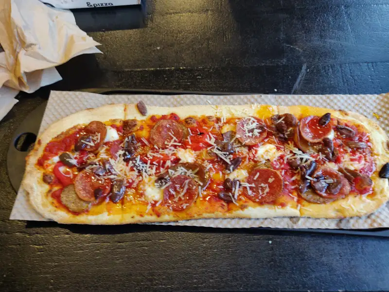 Homemade pizza with tomato, mozzarella, and basil.
