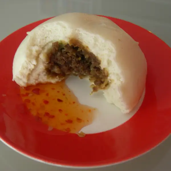 Bapao, piccoli panini al vapore ripieni di carne di maiale speziata.
