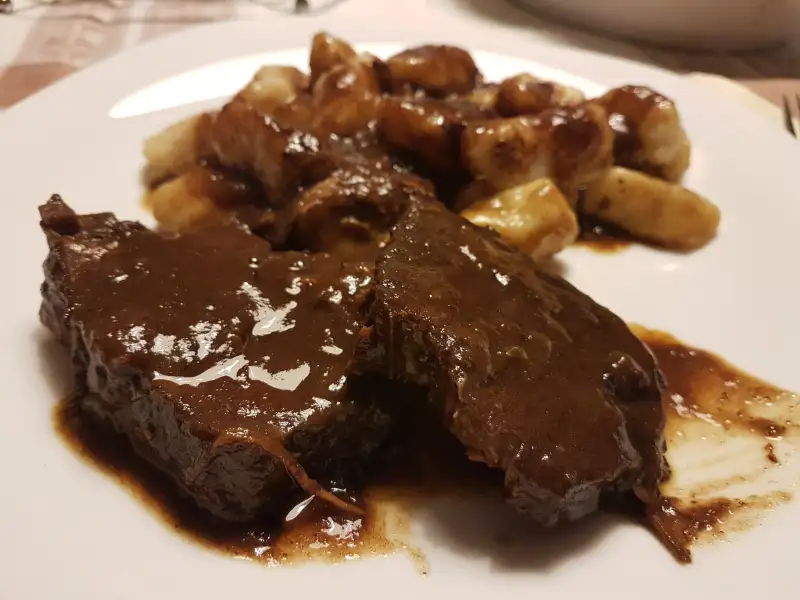 Pašticada, carne bovina cozida em vinho e com passas, nhoque caseiro