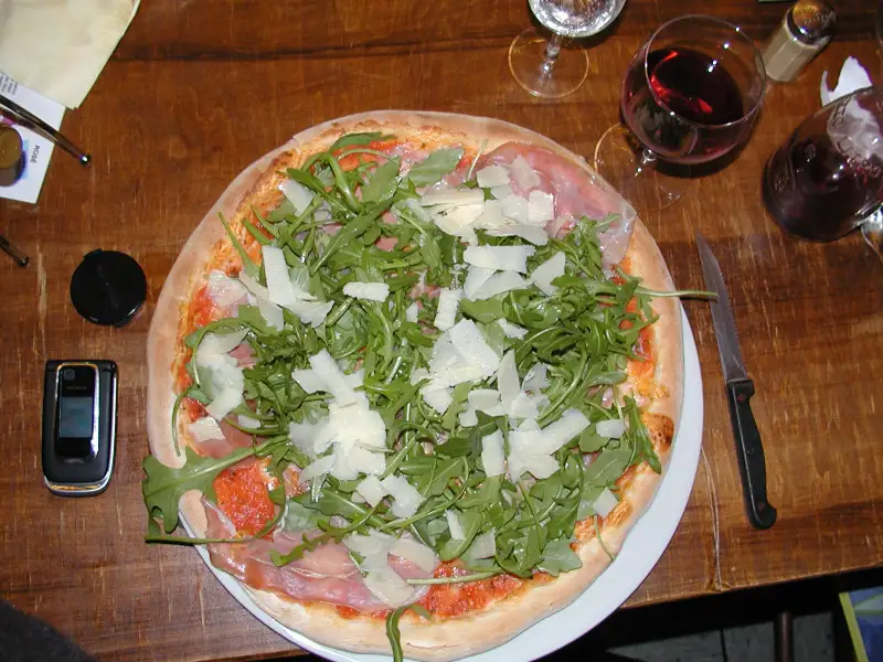 Pizza com tomate, mussarela e rúcula