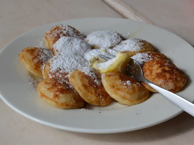 Poffertjes holandeses, açúcar de confeiteiro e manteiga