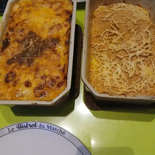 Poireaux au gratin dorés et purée maison gratinée à la chapelure, dans deux plats à gratin sur une table verte