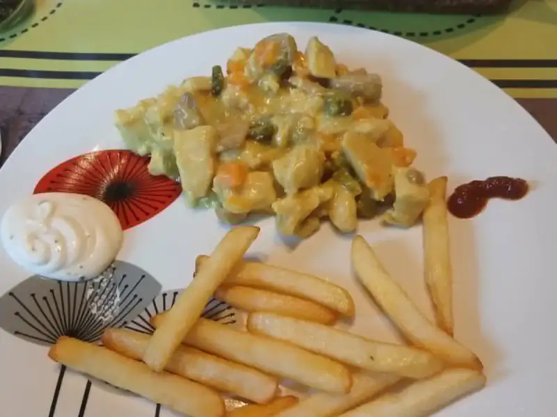 Snelle vol-au-vent met kip, champignons, wortelen en erwtjes in kurkumasaus, geserveerd met frietjes en mayonaise