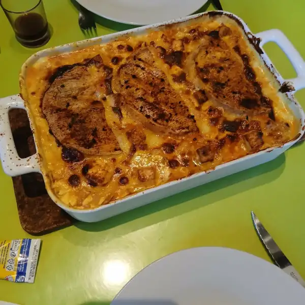 Tartiflette à la feta gratinée et dorée, servie dans un plat à gratin blanc