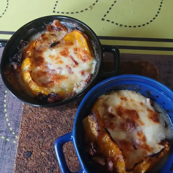 Deux cocottes de tomate jaune, mozzarella et lardons gratinés