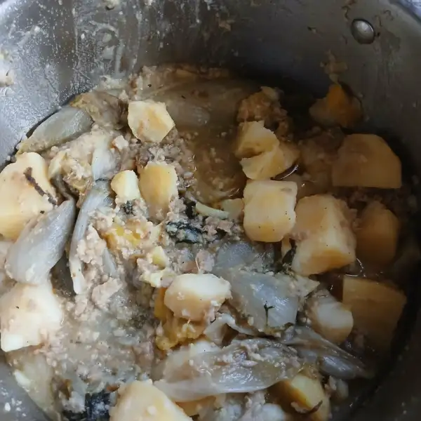 Witloof, gehakt en aardappelen die sudderen in een inox kookpot